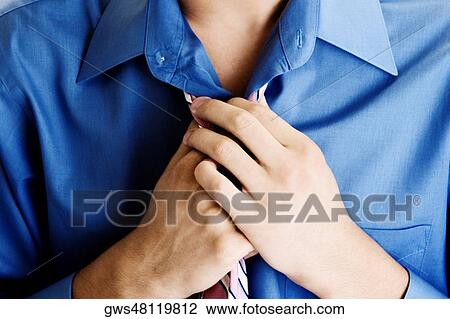 Close-up of a young man adjusting his tie View Large Photo Image Stock Image - Close-up of a young man adjusting his tie. Fotosearch