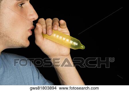 Close-up of a young man blowing a condom View Large Photo Image Picture - Close-up of a young man blowing a condom. Fotosearch