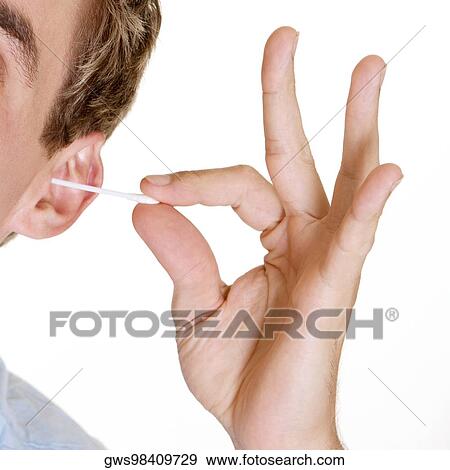 Close-up of a young man cleaning his ear with a cotton swab View Large Photo Image Stock Photo - Close-up of a young man cleaning his ear with a cotton swab. Fotosearch