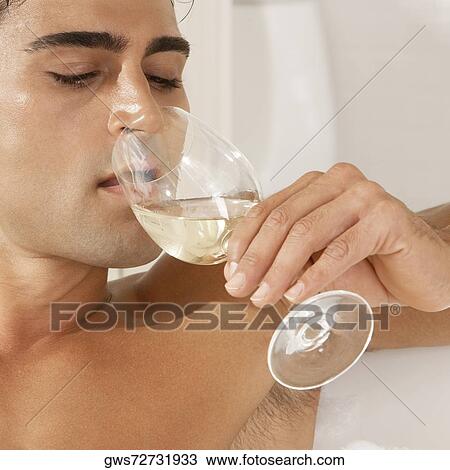 Close-up of a young man drinking white wine View Large Photo Image Stock Image - Close-up of a young man drinking white wine. Fotosearch