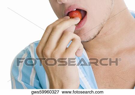 Close-up of a young man eating a strawberry View Large Photo Image Stock Photo - Close-up of a young man eating a strawberry. Fotosearch