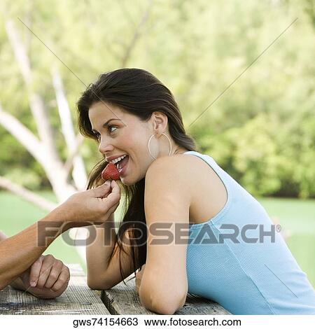 Close-up of a young man feeding a young woman a strawberry View Large Photo Image Stock Image - Close-up of a young man feeding a young woman a strawberry. Fotosearch
