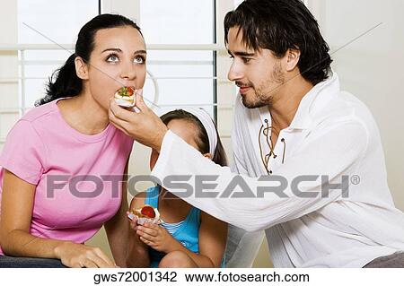 Close-up of a young man feeding pastry to a young woman View Large Photo Image Stock Image - Close-up of a young man feeding pastry to a young woman. Fotosearch