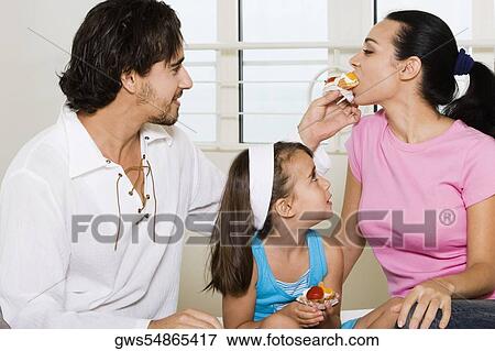 Close-up of a young man feeding pastry to a young woman View Large Photo Image Stock Photo - Close-up of a young man feeding pastry to a young woman. Fotosearch