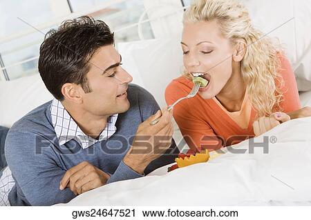 Close-up of a young man feeding salad to a young woman View Large Photo Image Stock Image - Close-up of a young man feeding salad to a young woman. Fotosearch