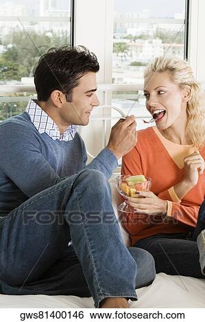 Close-up of a young man feeding salad to a young woman View Large Photo Image Stock Photograph - Close-up of a young man feeding salad to a young woman. Fotosearch
