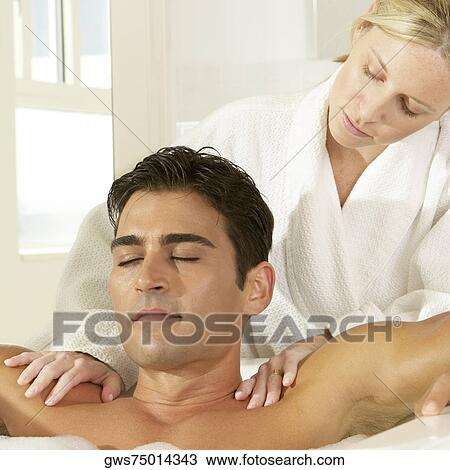 Stock Image - Close-up of a young man getting a massage from a massage therapist. Fotosearch