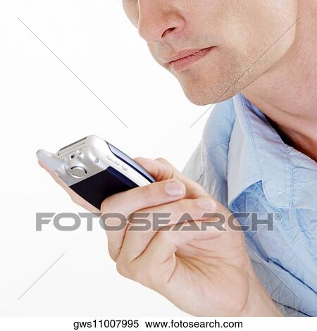 Close-up of a young man holding a mobile phone View Large Photo Image Stock Photography - Close-up of a young man holding a mobile phone. Fotosearch