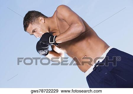 Close-up of a young man in a fighting stance View Large Photo Image Stock Photo - Close-up of a young man in a fighting stance. Fotosearch