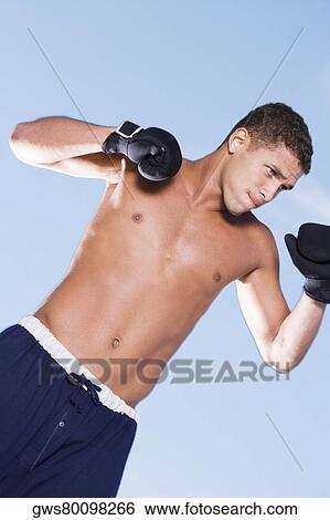 Close-up of a young man in a fighting stance View Large Photo Image Stock Photograph - Close-up of a young man in a fighting stance. Fotosearch
