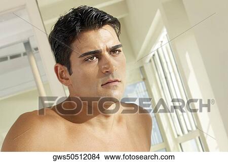 Close-up of a young man looking serious View Large Photo Image Picture - Close-up of a young man looking serious. Fotosearch