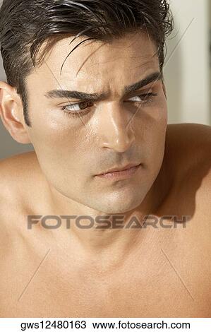 Close-up of a young man looking serious View Large Photo Image Stock Image - Close-up of a young man looking serious. Fotosearch
