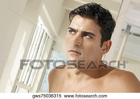 Close-up of a young man looking serious View Large Photo Image Stock Photography - Close-up of a young man looking serious. Fotosearch