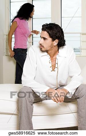 Close-up of a young man sitting with a young woman standing behind him View Large Photo Image Stock Photography - Close-up of a young man sitting with a young woman standing behind him. Fotosearch