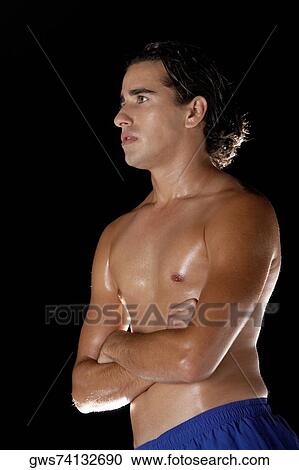 Close-up of a young man standing with his arms crossed View Large Photo Image Stock Image - Close-up of a young man standing with his arms crossed. Fotosearch