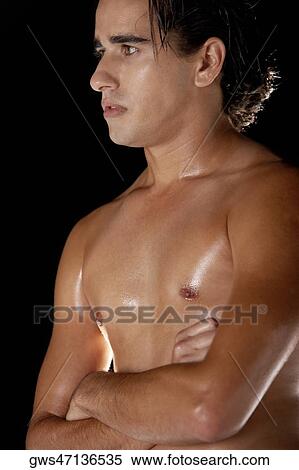 Stock Photography - Close-up of a young man standing with his arms crossed. Fotosearch