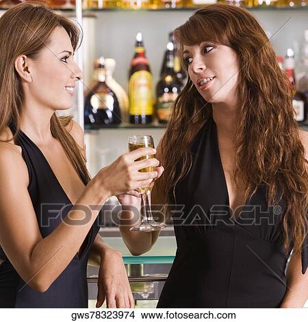 Close-up of a young woman and a mid adult woman toasting View Large Photo Image Picture - Close-up of a young woman and a mid adult woman toasting. Fotosearch
