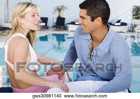 Close-up of a young woman and a mid adult man looking at each other View Large Photo Image Stock Image - Close-up of a young woman and a mid adult man looking at each other. Fotosearch