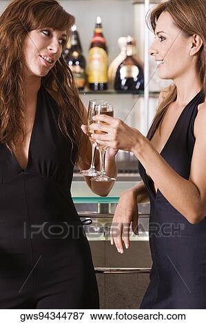 Stock Photo - Close-up of a young woman and a mid adult woman toasting. Fotosearch