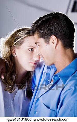 Close-up of a young woman and a mid adult man embracing each other View Large Photo Image Stock Photograph - Close-up of a young woman and a mid adult man embracing each other. Fotosearch