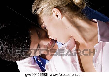 Stock Photograph - Close-up of a young woman and a mid adult man embracing each other. Fotosearch