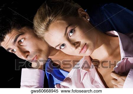 Stock Photography - Close-up of a young woman and a mid adult man embracing each other. Fotosearch