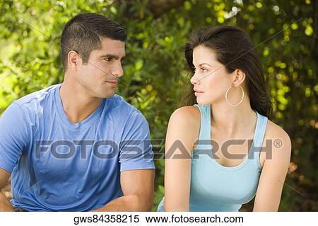 Close-up of a young woman and a mid adult man looking at each other View Large Photo Image Stock Photography - Close-up of a young woman and a mid adult man looking at each other. Fotosearch