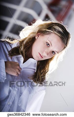 Close-up of a young woman buttoning her shirt View Large Photo Image Stock Photograph - Close-up of a young woman buttoning her shirt. Fotosearch