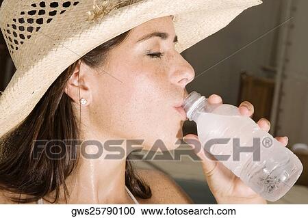Close-up of a young woman drinking water from a bottle View Large Photo Image Stock Image - Close-up of a young woman drinking water from a bottle. Fotosearch