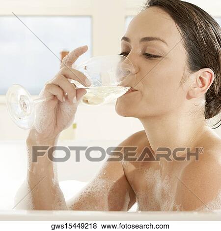 Close-up of a young woman drinking white wine in the bathtub View Large Photo Image Stock Photo - Close-up of a young woman drinking white wine in the bathtub. Fotosearch