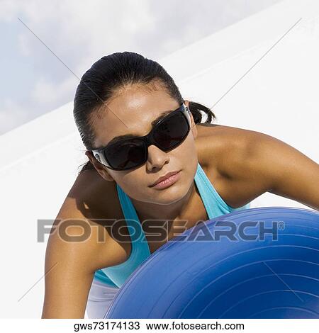 Close-up of a young woman exercising with a fitness ball View Large Photo Image Stock Image - Close-up of a young woman exercising with a fitness ball. Fotosearch