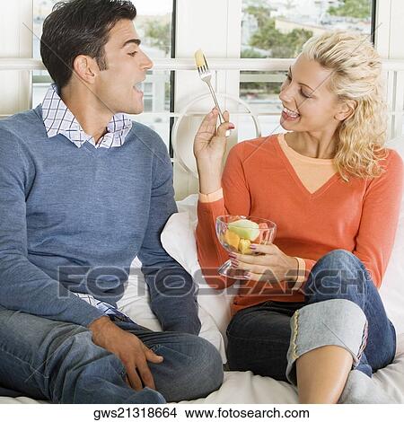 Close-up of a young woman feeding salad to a young man View Large Photo Image Picture - Close-up of a young woman feeding salad to a young man. Fotosearch