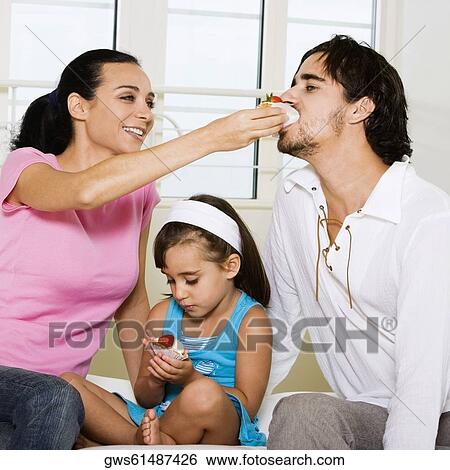 Close-up of a young woman feeding pastry to a young man View Large Photo Image Stock Photograph - Close-up of a young woman feeding pastry to a young man. Fotosearch