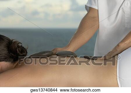 Picture - Close-up of a young woman getting a back massage. Fotosearch