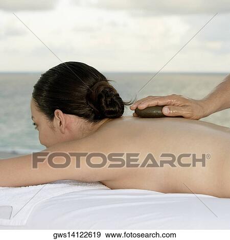 Close-up of a young woman getting a back massage View Large Photo Image Stock Photo - Close-up of a young woman getting a back massage. Fotosearch