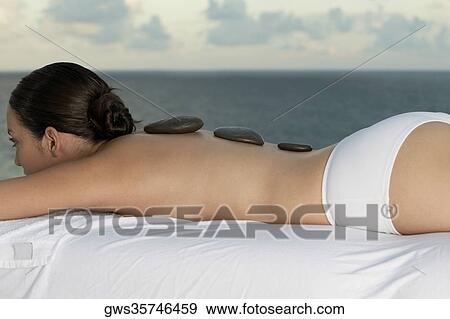 Close-up of a young woman getting hot stone therapy View Large Photo Image Stock Photo - Close-up of a young woman getting hot stone therapy. Fotosearch