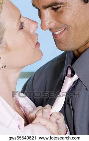 Close-up of a young woman holding a mid adult man by his tie View Large Photo Image Stock Image - Close-up of a young woman holding a mid adult man by his tie. Fotosearch