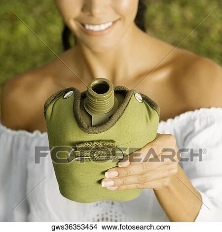 Close-up of a young woman holding a water bottle View Large Photo Image Picture - Close-up of a young woman holding a water bottle. Fotosearch