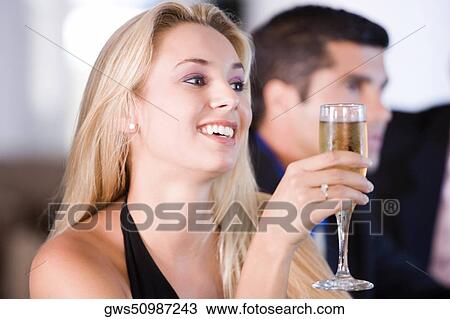 Close-up of a young woman holding a glass of champagne View Large Photo Image Stock Image - Close-up of a young woman holding a glass of champagne. Fotosearch