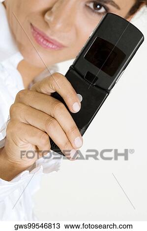 Close-up of a young woman holding a mobile phone View Large Photo Image Stock Image - Close-up of a young woman holding a mobile phone. Fotosearch