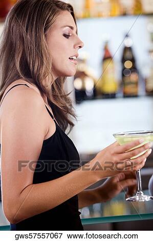 Close-up of a young woman holding a glass of cocktail View Large Photo Image Stock Photo - Close-up of a young woman holding a glass of cocktail. Fotosearch