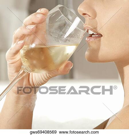 Close-up of a young woman holding a glass of a wine in a bathtub View Large Photo Image Stock Photo - Close-up of a young woman holding a glass of a wine in a bathtub. Fotosearch