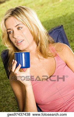 Close-up of a young woman holding a coffee cup View Large Photo Image Stock Photo - Close-up of a young woman holding a coffee cup. Fotosearch