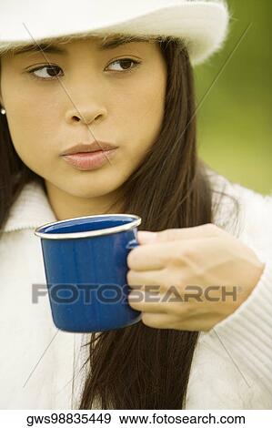 Close-up of a young woman holding a coffee cup View Large Photo Image Stock Photo - Close-up of a young woman holding a coffee cup. Fotosearch