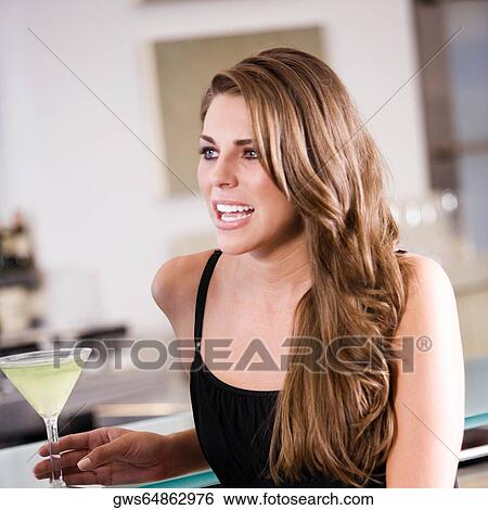 Close-up of a young woman holding a glass of cocktail View Large Photo Image Stock Photograph - Close-up of a young woman holding a glass of cocktail. Fotosearch