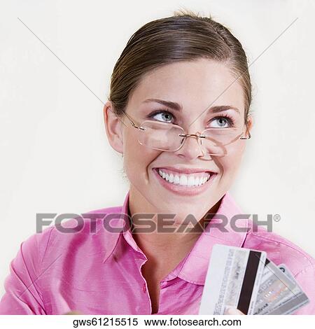 Close-up of a young woman holding a credit card and smiling View Large Photo Image Stock Photography - Close-up of a young woman holding a credit card and smiling. Fotosearch