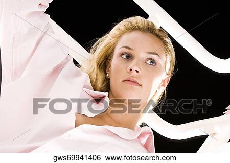 Close-up of a young woman looking away View Large Photo Image Stock Photograph - Close-up of a young woman looking away. Fotosearch