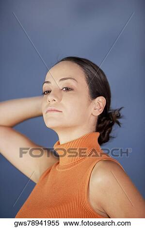 Close-up of a young woman looking away with her hands behind her head View Large Photo Image Stock Photography - Close-up of a young woman looking away with her hands behind her head. Fotosearch