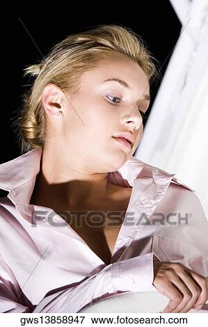 Close-up of a young woman looking down View Large Photo Image Stock Photo - Close-up of a young woman looking down. Fotosearch