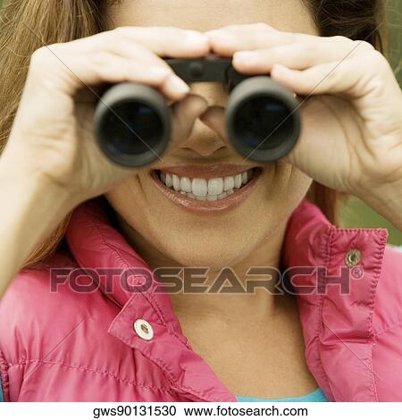 Close-up of a young woman looking through a pair of binoculars View Large Photo Image Stock Image - Close-up of a young woman looking through a pair of binoculars. Fotosearch